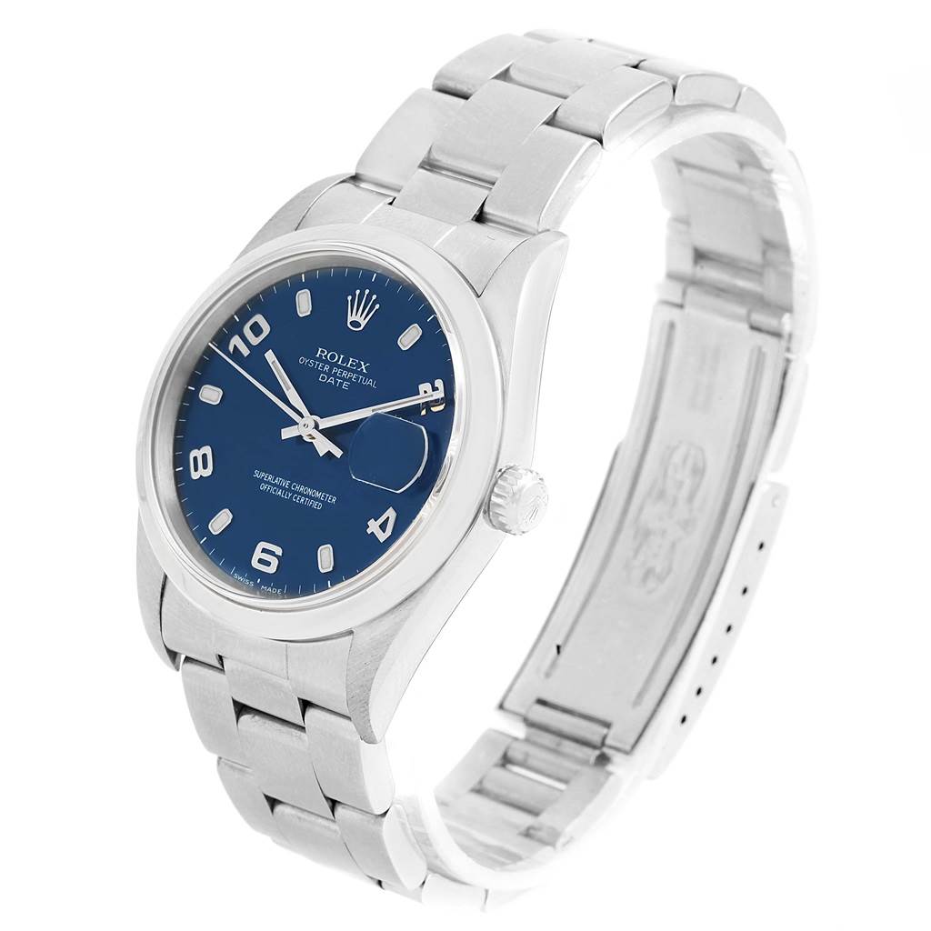 The image shows a Rolex Oyster Perpetual Date model watch with a blue dial and stainless steel bracelet, viewed at a slight angle.