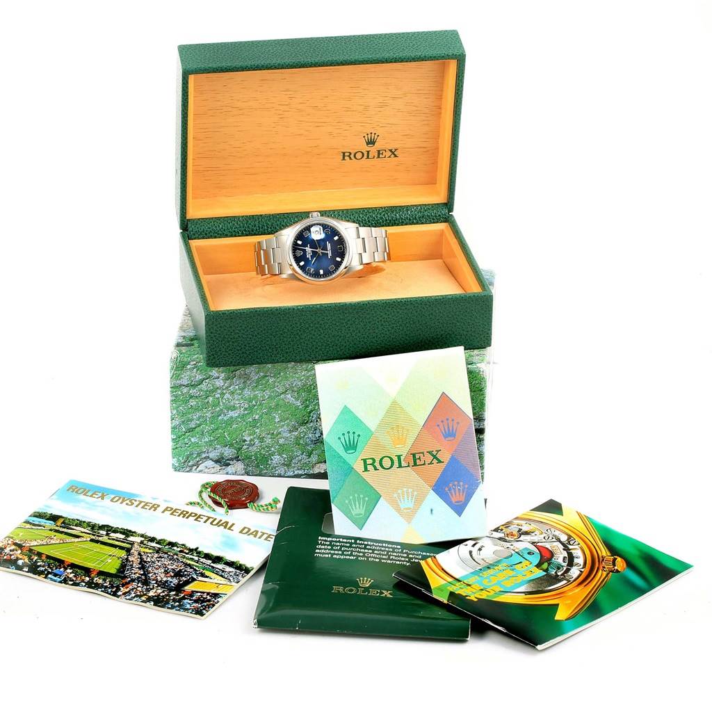The Rolex Date 15200 Men's Stainless Steel Blue Dial 15200 Men's Stainless Steel Blue Dial model watch is displayed in an open box, accompanied by various booklets and leaflets.