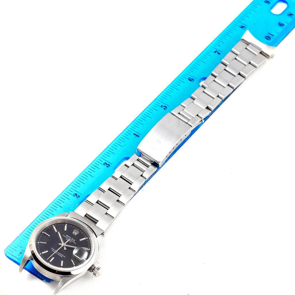 The image shows a Rolex Date 15200 Men's Stainless Steel Black Dial 15200 Men's Stainless Steel Black Dial watch with a full bracelet placed against a ruler, displaying the watch face and clasp.