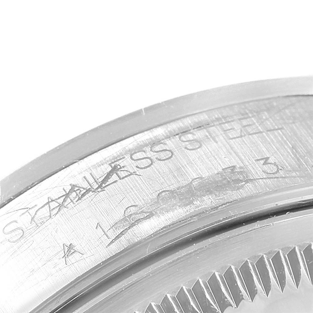 The image shows a close-up of the side of a Rolex Date 15200 Men's Stainless Steel Black Dial 15200 Men's Stainless Steel Black Dial model's stainless steel case, highlighting the engraved text and serial number.