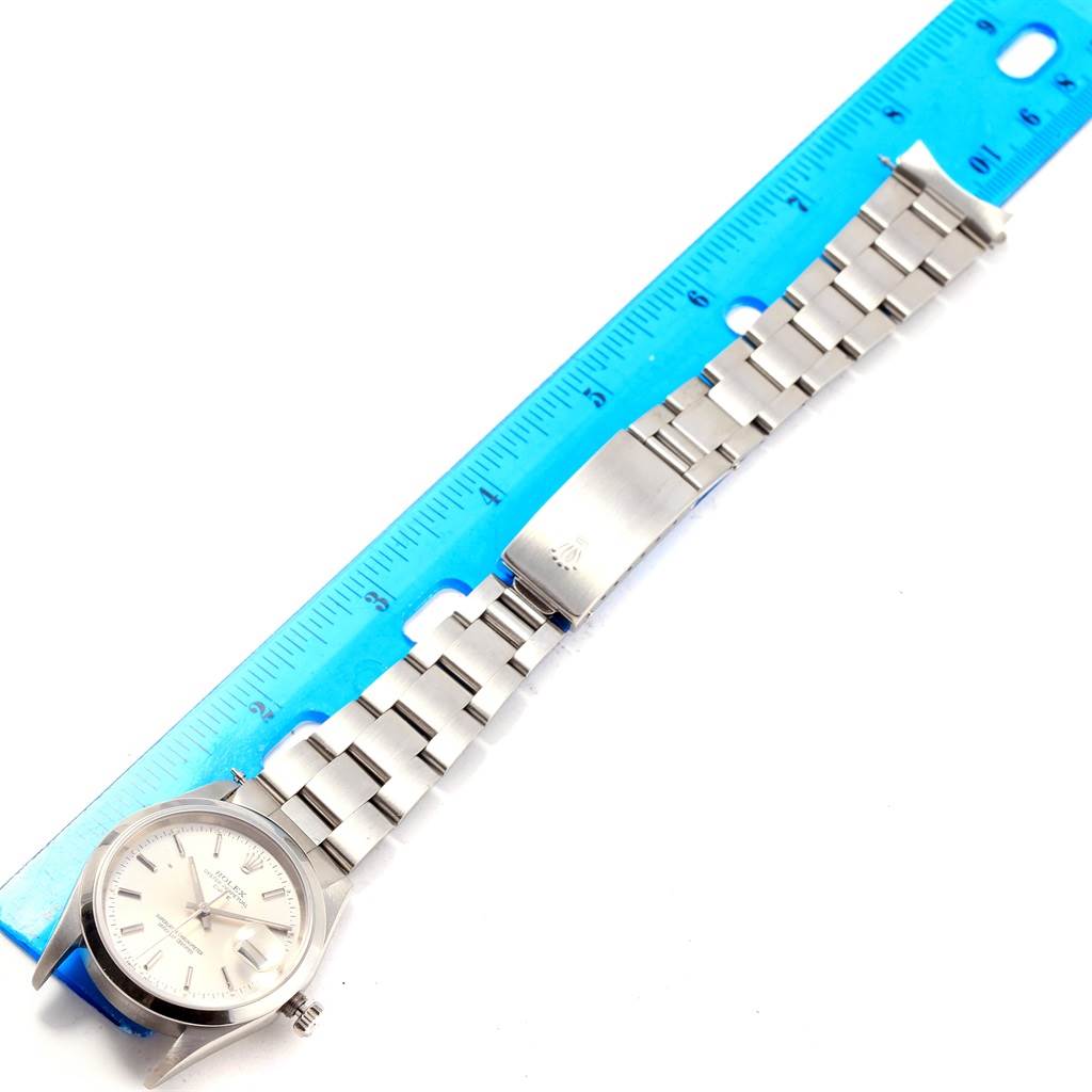 The Rolex Date 15200 Men's Stainless Steel Silver Dial 15200 Men's Stainless Steel Silver Dial model watch is shown from a top-down angle, displaying its face, bezel, and band alongside a ruler for measurement.