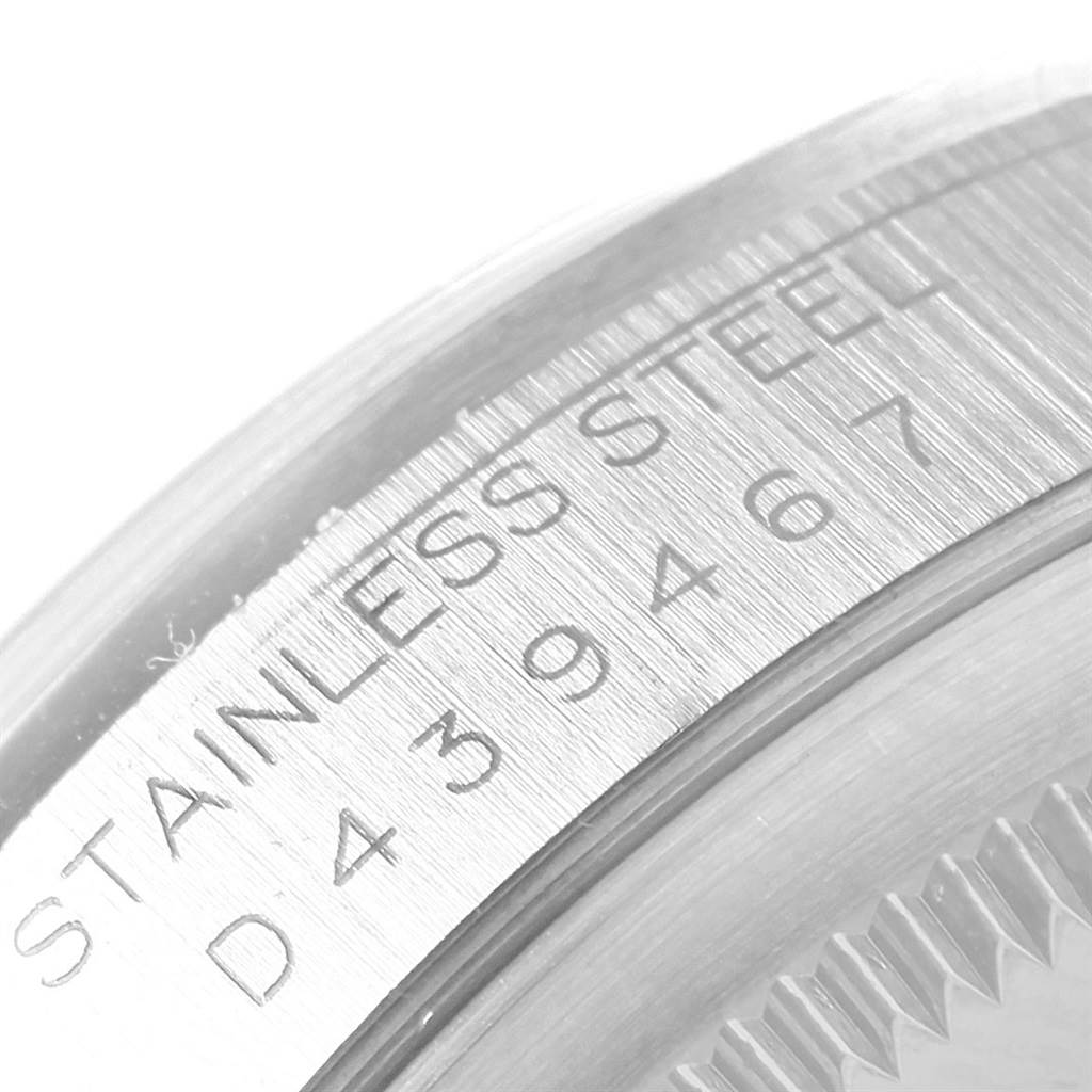 This is a close-up angled view of the serial number engraving on the stainless steel case back of a Rolex Date 16200 Men's Stainless Steel Black Dial 16200 Men's Stainless Steel Black Dial model watch.