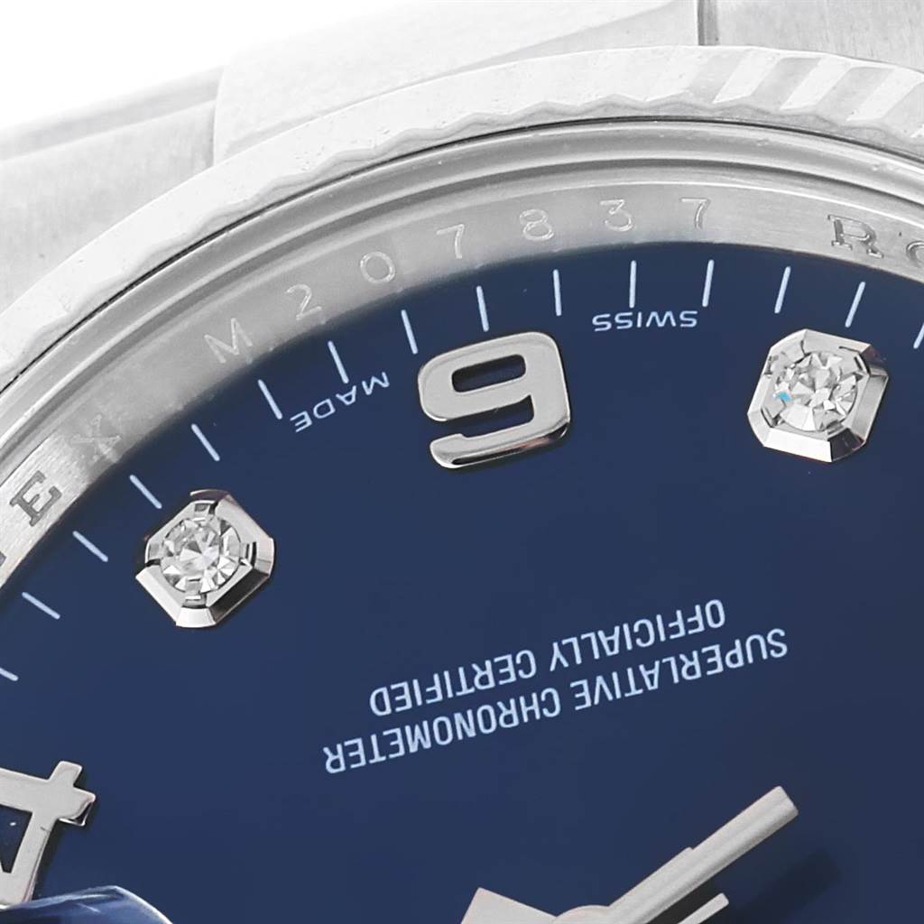 This close-up image of the Rolex Date 115234 Stainless Steel Blue Dial 115234 Stainless Steel Blue Dial model shows the blue dial with diamond hour markers around the 9 o'clock position.