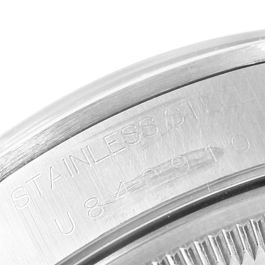 The image shows a close-up of the engraved serial number on the stainless steel back of a Rolex Date 15200 Men's Stainless Steel Black Dial 15200 Men's Stainless Steel Black Dial watch.