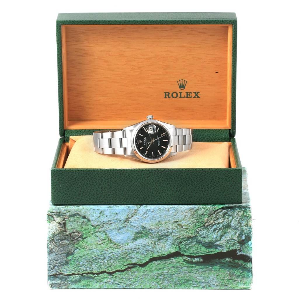 The Rolex Date 15200 Men's Stainless Steel Black Dial 15200 Men's Stainless Steel Black Dial model watch is shown from the front, placed in an open green and wooden box.