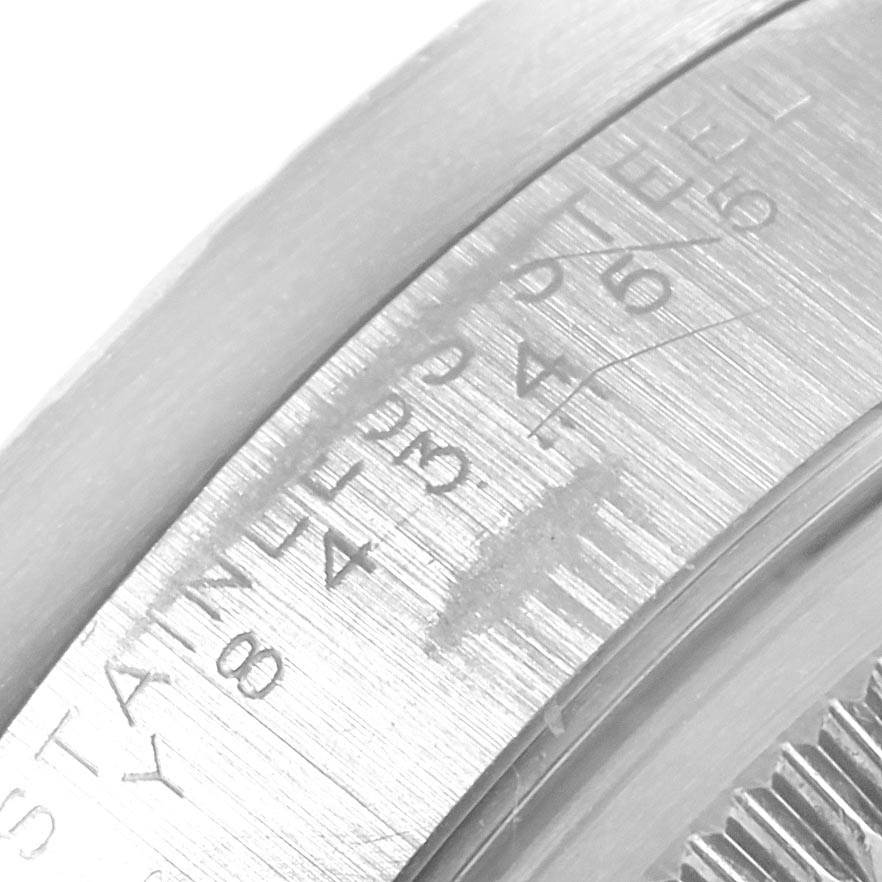 This close-up image of the Rolex Date 15210 Men's Stainless Steel Blue Dial 15210 Men's Stainless Steel Blue Dial model shows the engraved inner side of the watch case and part of the bezel.