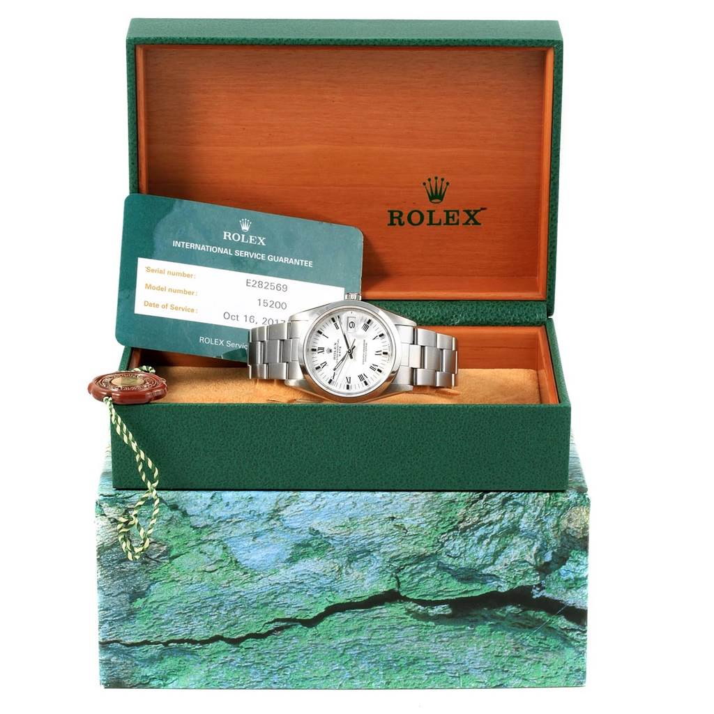 The Rolex Date 15200 Men's Stainless Steel White Dial 15200 Men's Stainless Steel White Dial model is shown inside its box, accompanied by its warranty card and service tag.