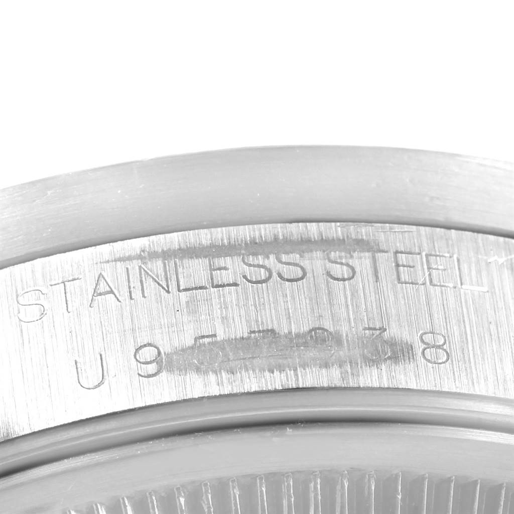 The image shows a close-up of the case back and serial number of a Rolex Date 15210 Men's Stainless Steel Blue Dial 15210 Men's Stainless Steel Blue Dial model watch with the text "STAINLESS STEEL."