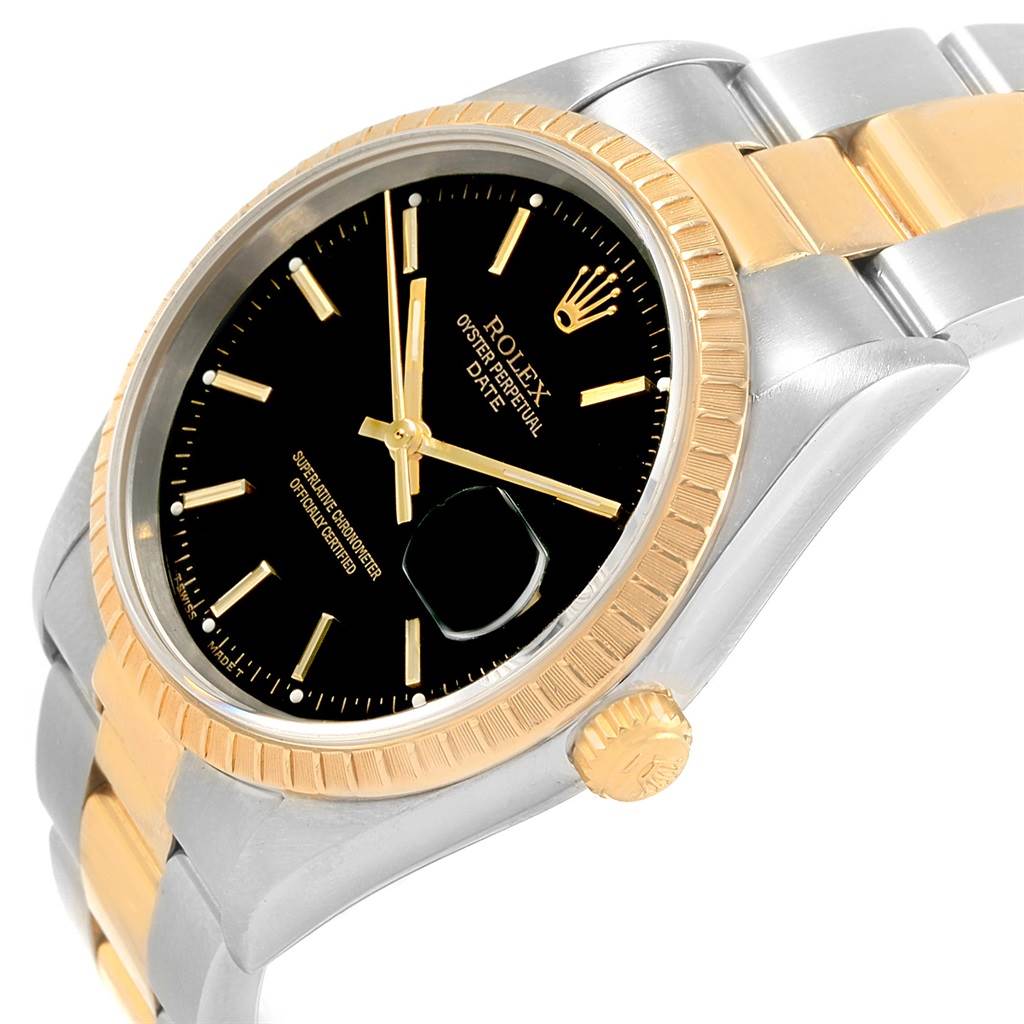 This image shows a Rolex Date 15223 Men's Steel and Gold (two tone) Black Dial 15223 Men's Steel and Gold (two tone) Black Dial model watch from an oblique angle, highlighting the black dial, gold fluted bezel, and two-tone bracelet.