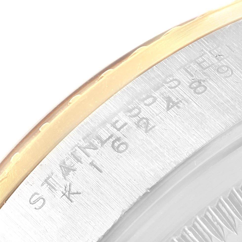 This image shows a close-up of the edge of the case back of the Rolex Date 15223 Men's Steel and Gold (two tone) Black Dial 15223 Men's Steel and Gold (two tone) Black Dial model watch, highlighting its engraved text and part of the bezel.