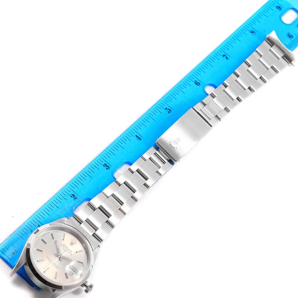 This is a top-down view of a Rolex Date 15200 Men's Stainless Steel Silver Dial 15200 Men's Stainless Steel Silver Dial model watch, showing its face, bracelet, and clasp alongside a blue ruler for scale.