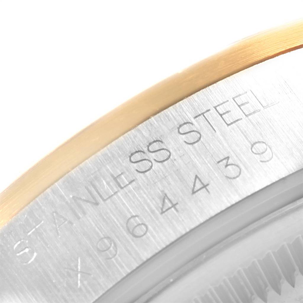 The image shows a close-up of the serial number and "STAINLESS STEEL" engraving on the edge of a Rolex Date 15203 Men's Steel and Gold (two tone) Black Dial 15203 Men's Steel and Gold (two tone) Black Dial model watch.