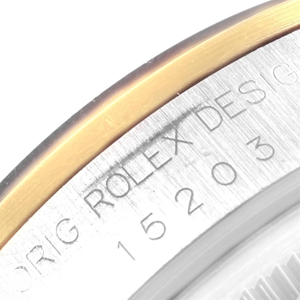 This close-up image shows the bezel and engraved reference number of a Rolex Date 15203 Men's Steel and Gold (two tone) Black Dial 15203 Men's Steel and Gold (two tone) Black Dial watch.