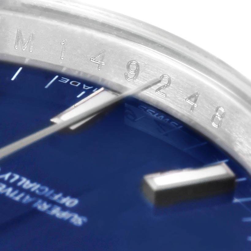 The image shows a close-up of the dial and bezel of a Rolex Date 115210 Men's Stainless Steel Blue Dial 115210 Men's Stainless Steel Blue Dial model, highlighting part numbers and the "Swiss Made" label.
