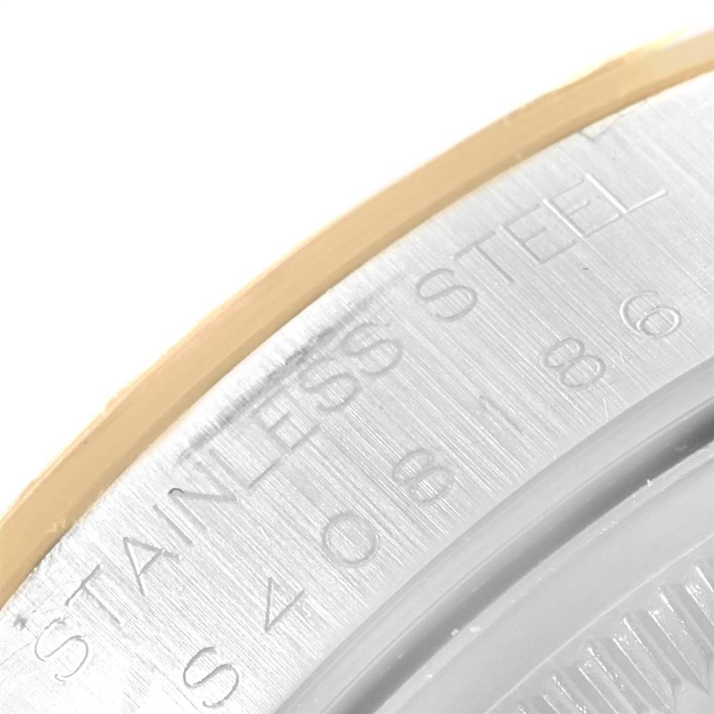 The image shows a close-up view of the engraved stainless steel case back of a Rolex Date 15223 Men's Steel and Gold (two tone) Champagne Dial 15223 Men's Steel and Gold (two tone) Champagne Dial model watch.