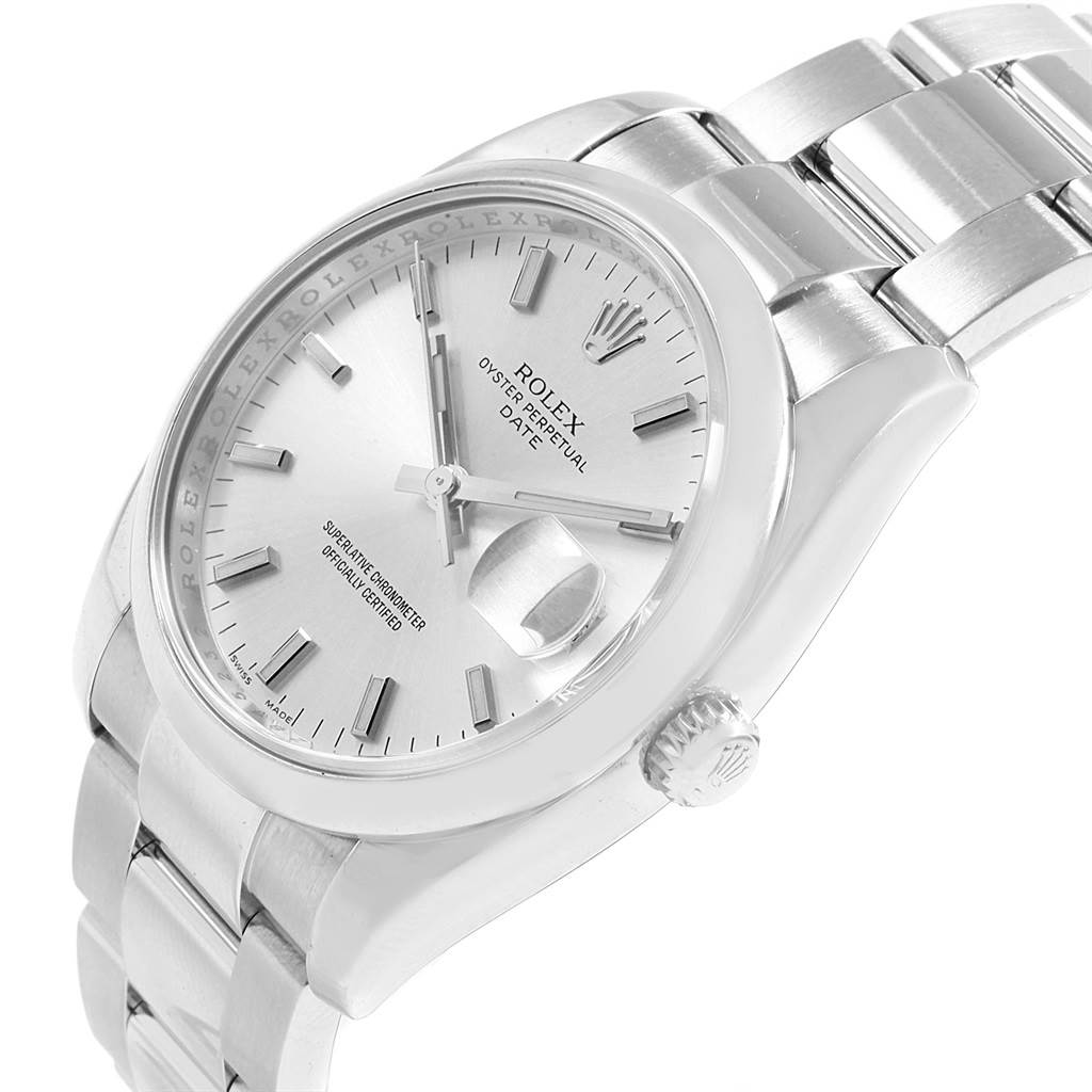 The image shows a close-up of a Rolex Date 115200 Men's Stainless Steel Silver Dial 115200 Men's Stainless Steel Silver Dial model watch from a slight front-left angle, highlighting the dial, crown, and bracelet.