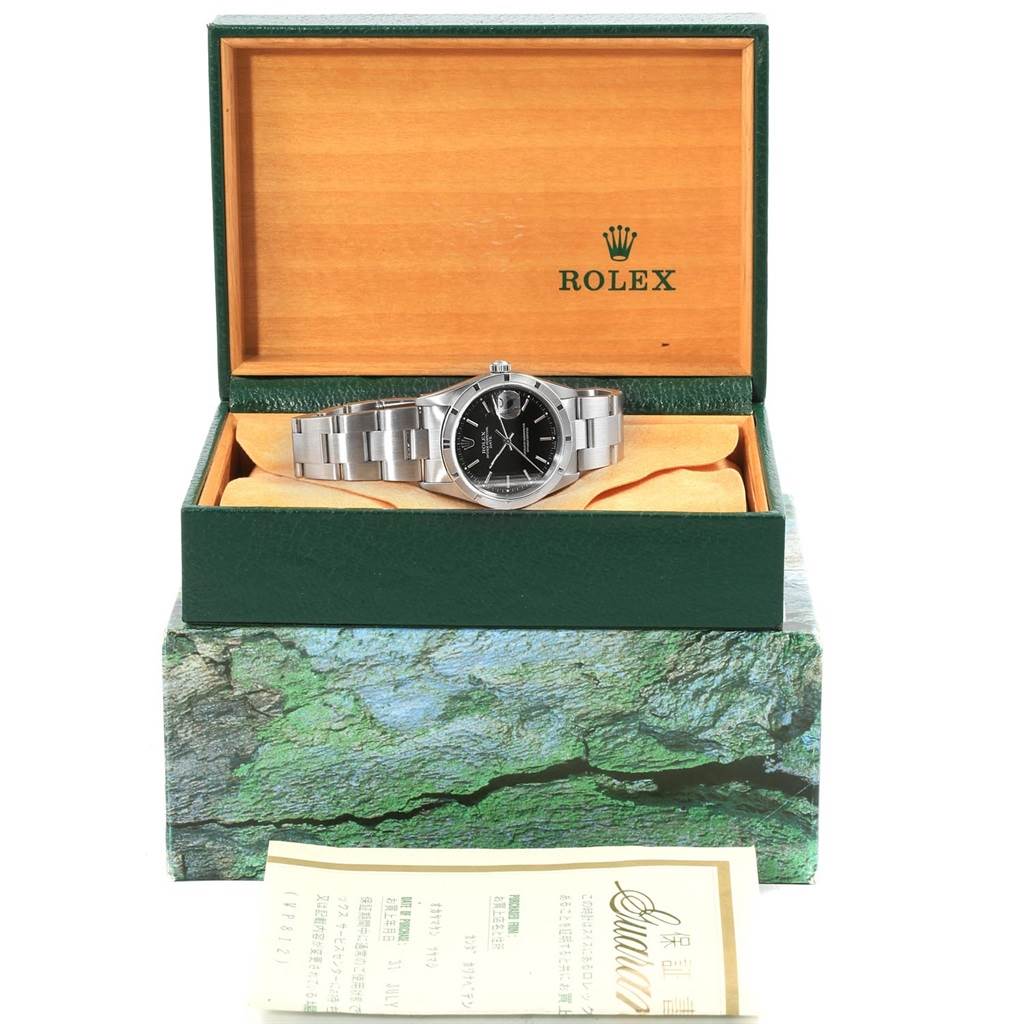 The image shows a Rolex Date 15210 Men's Stainless Steel Black Dial 15210 Men's Stainless Steel Black Dial model watch in its open box at a front-facing angle, with additional documents below the box.