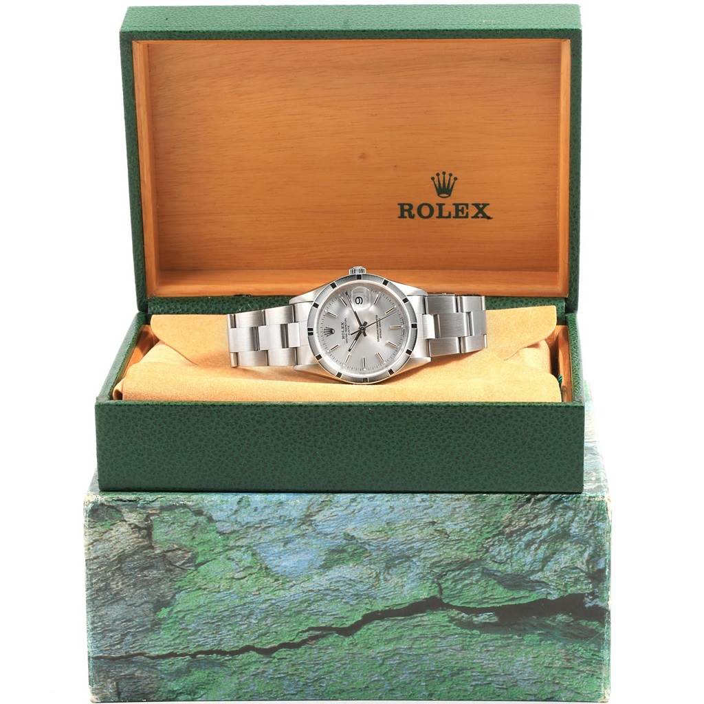 The Rolex Date 15210 Men's Stainless Steel Silver Dial 15210 Men's Stainless Steel Silver Dial model watch is shown from the front, resting inside its open green and wooden box.