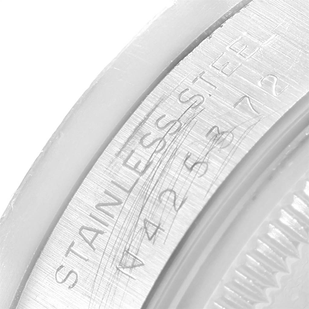This image shows a close-up of the engraved serial number and "STAINLESS STEEL" inscription on the case back of a Rolex Date 15210 Men's Stainless Steel White Dial 15210 Men's Stainless Steel White Dial model.