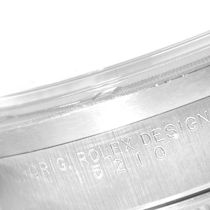 This image shows a close-up of the engraved serial number on the case of a Rolex Date 15210 Men's Stainless Steel Silver Dial 15210 Men's Stainless Steel Silver Dial model watch.