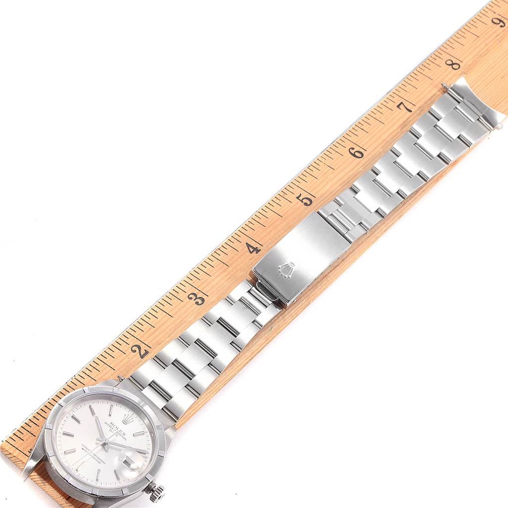 The image shows a Rolex Date 15210 Men's Stainless Steel Silver Dial 15210 Men's Stainless Steel Silver Dial model watch laid flat next to a ruler, highlighting the bracelet and clasp.