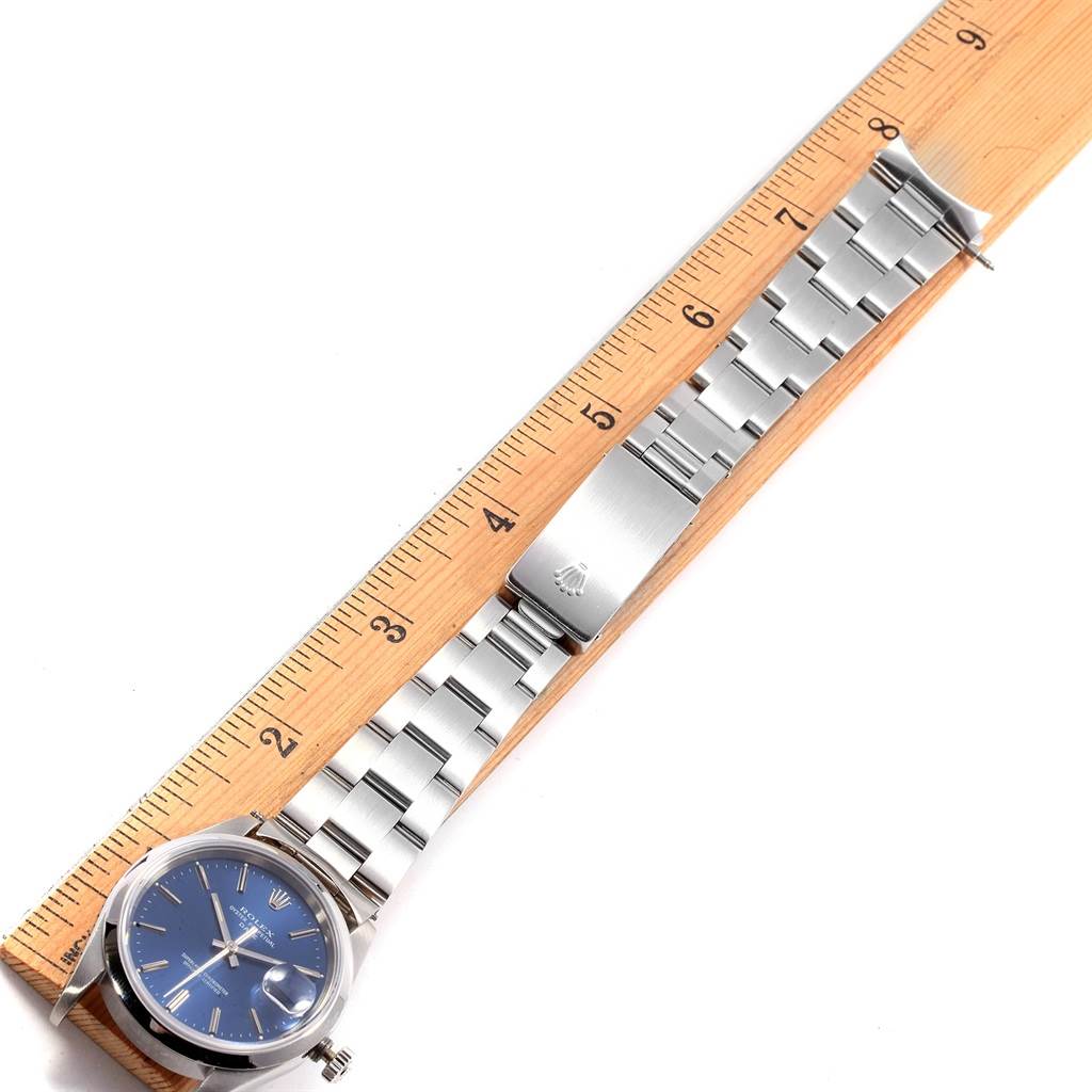 This image shows a Rolex Date 15200 Men's Stainless Steel Blue Dial 15200 Men's Stainless Steel Blue Dial watch laid flat next to a ruler, displaying its face, bracelet, and clasp.