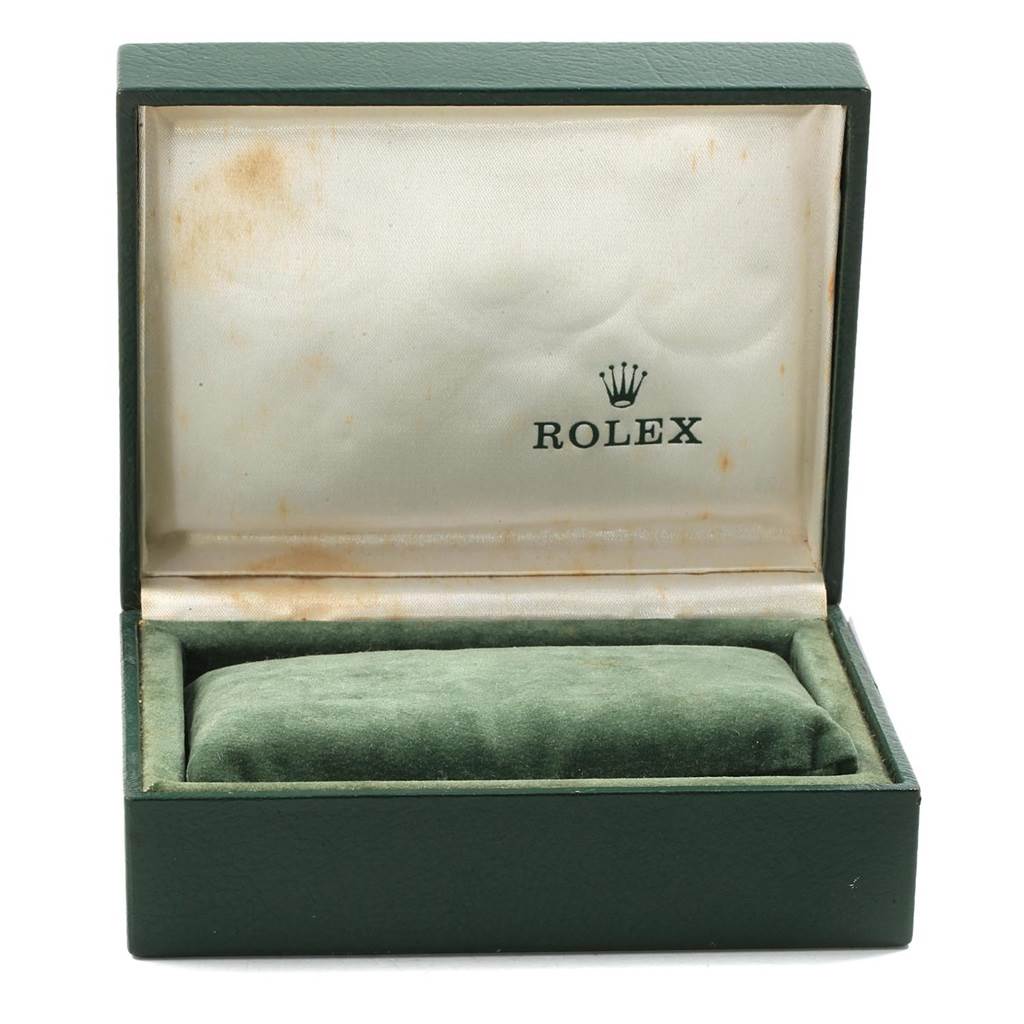 This image shows an open green Rolex watch box for the Date model, with a velvet cushion inside and the logo on the inner lid.