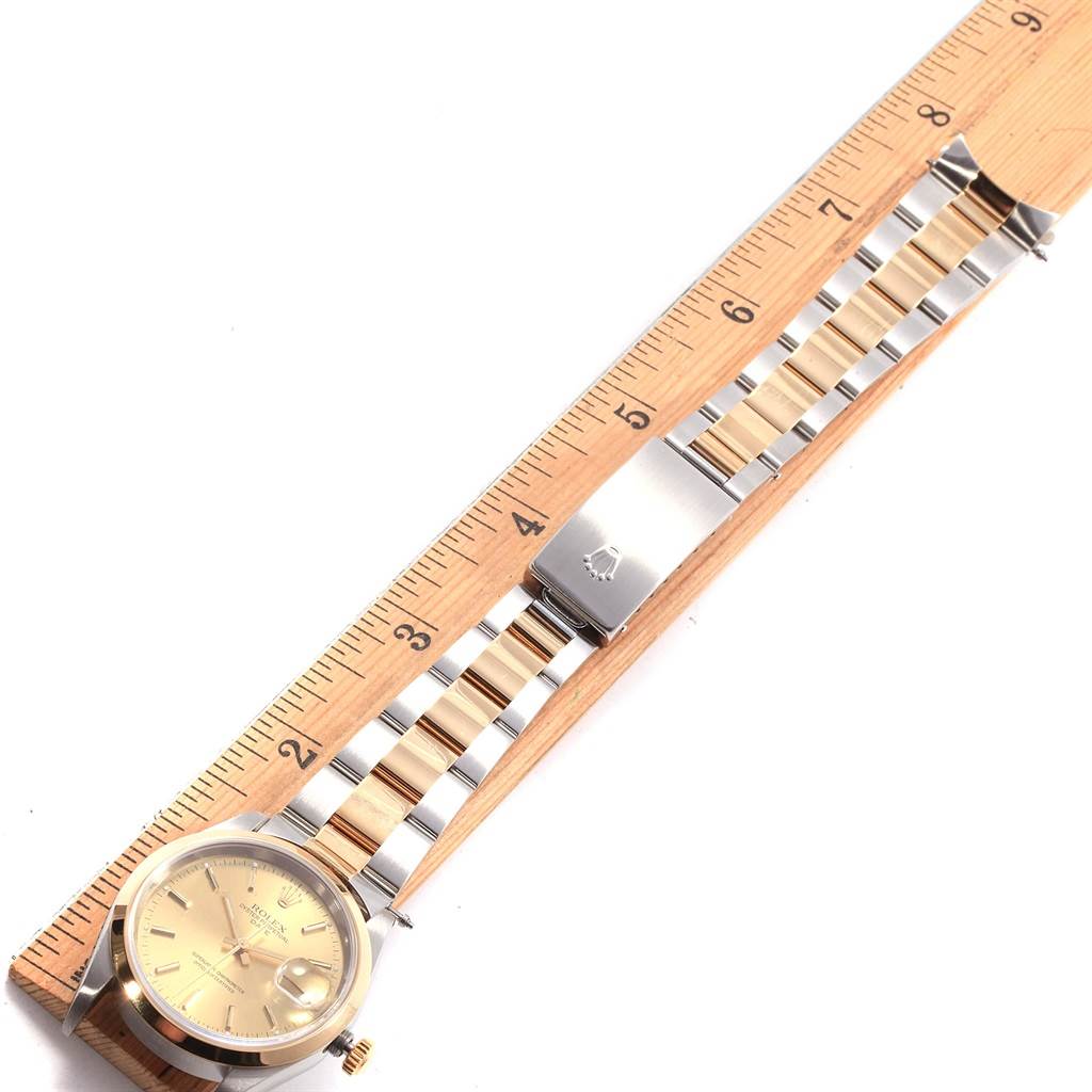 The image shows a Rolex Date 15203 Men's Steel and Gold (two tone) Champagne Dial 15203 Men's Steel and Gold (two tone) Champagne Dial model watch laid flat with its dial, bracelet and clasp visible next to a ruler for scale.