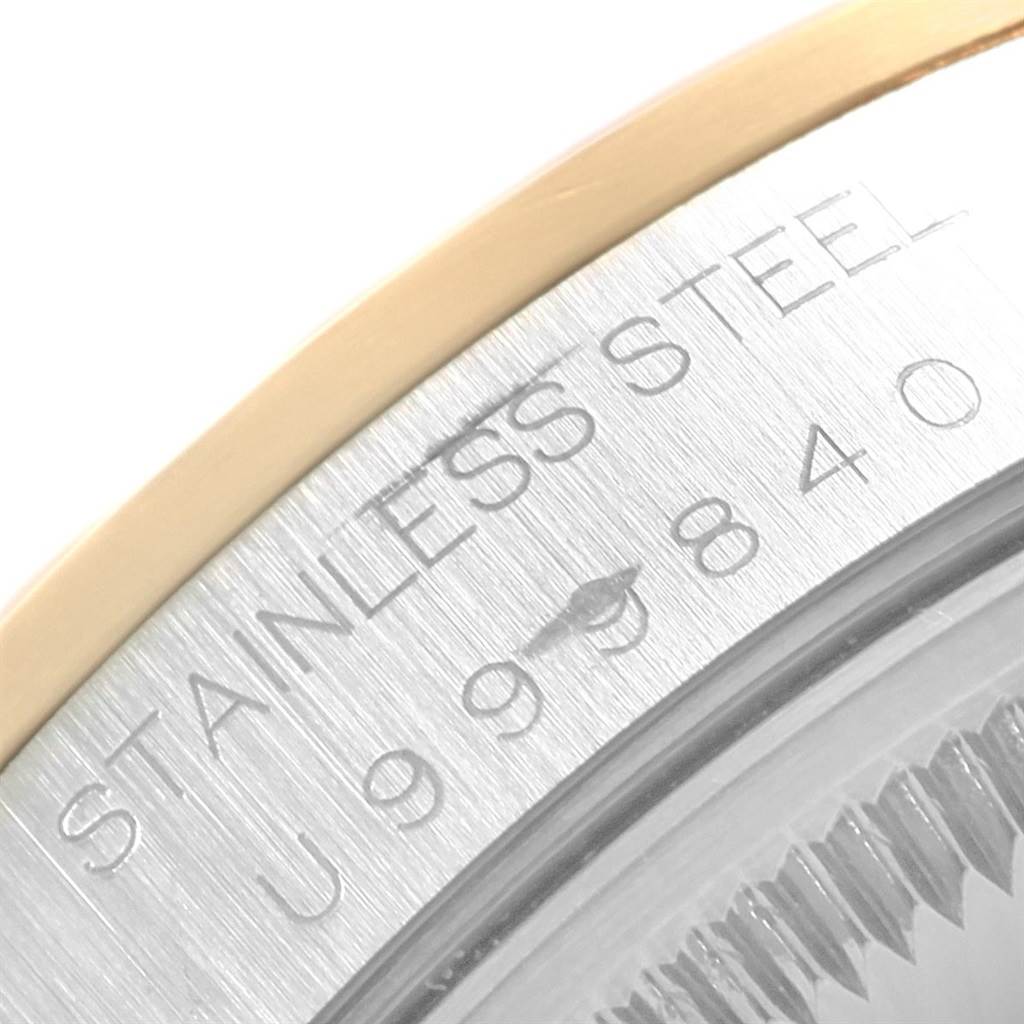 This image shows a close-up of the stainless steel bezel and serial number engraving on a Rolex Date 15203 Men's Steel and Gold (two tone) Champagne Dial 15203 Men's Steel and Gold (two tone) Champagne Dial model watch.