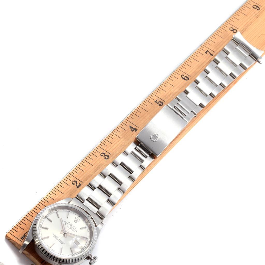 The image shows a Rolex Date 16220 Men's Stainless Steel Silver Dial 16220 Men's Stainless Steel Silver Dial model watch laid flat next to a ruler, highlighting the watchband and clasp.