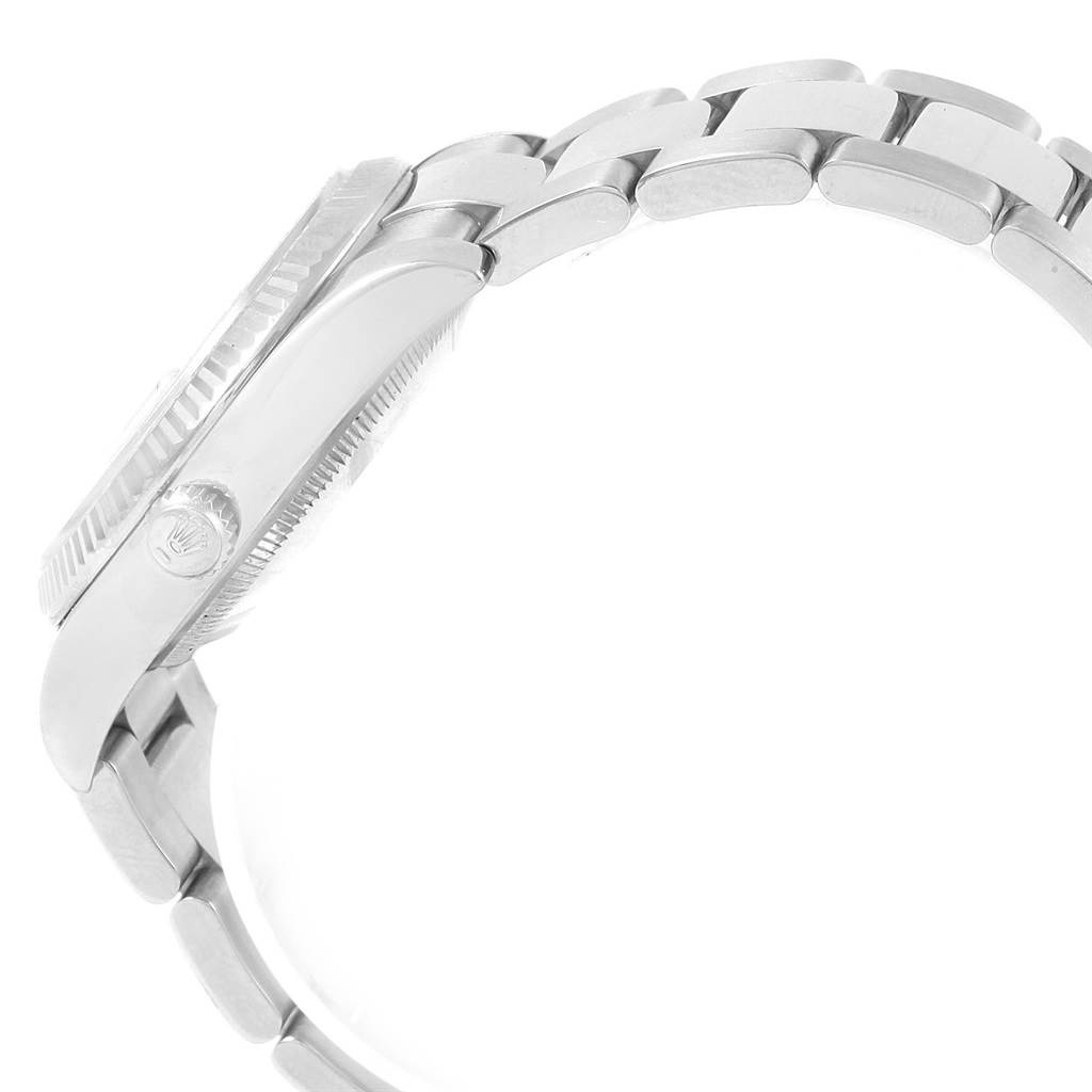 The Rolex Date 115234 Men's Stainless Steel Blue Dial 115234 Men's Stainless Steel Blue Dial watch is shown from a side angle, highlighting its case, bezel, crown, and part of the metal bracelet.