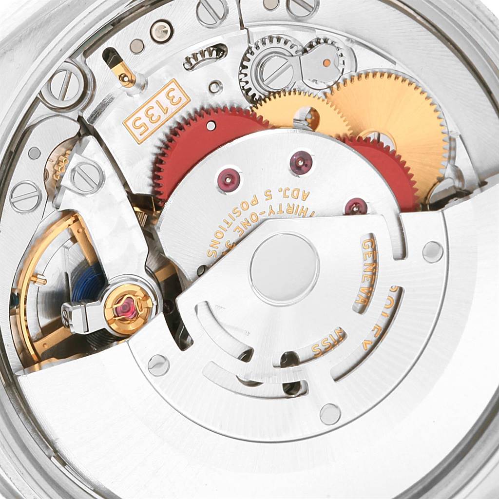 The image shows a close-up of the movement of a Rolex Date 115234 Men's Stainless Steel Blue Dial 115234 Men's Stainless Steel Blue Dial model watch, highlighting the gears, rotors, and internal mechanisms.