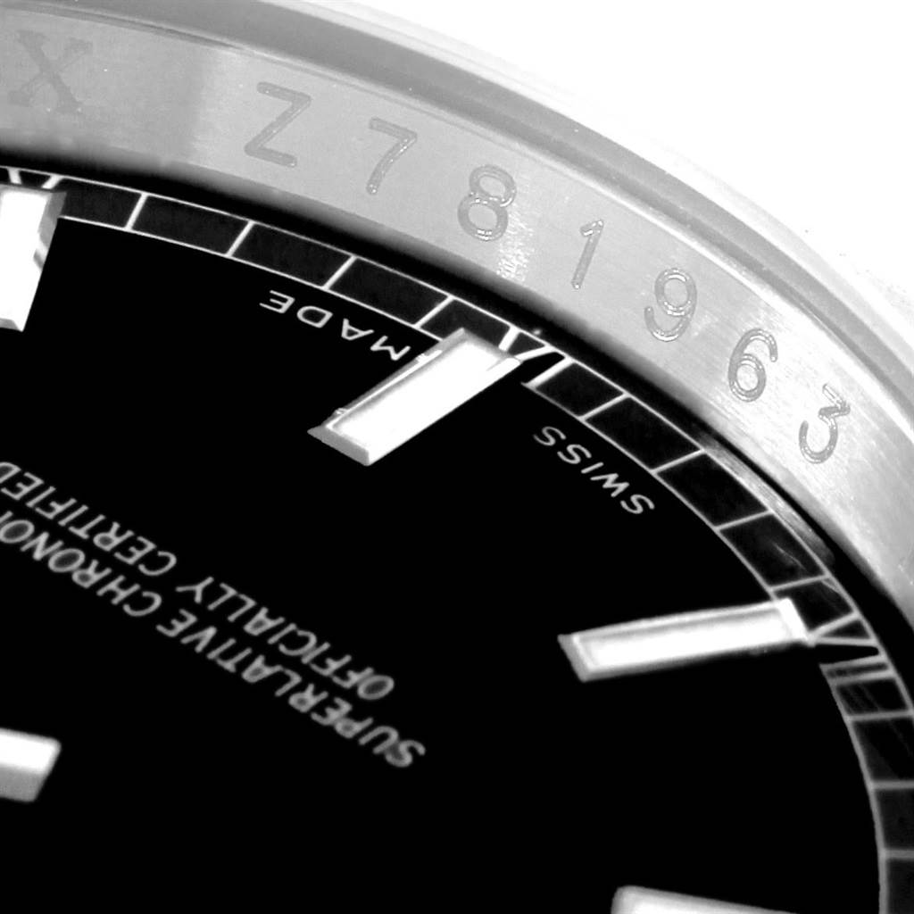 This close-up photo of the Rolex Date 116200 Men's Stainless Steel Black Dial 116200 Men's Stainless Steel Black Dial model shows the watch's bezel and part of the black dial with Swiss markings.