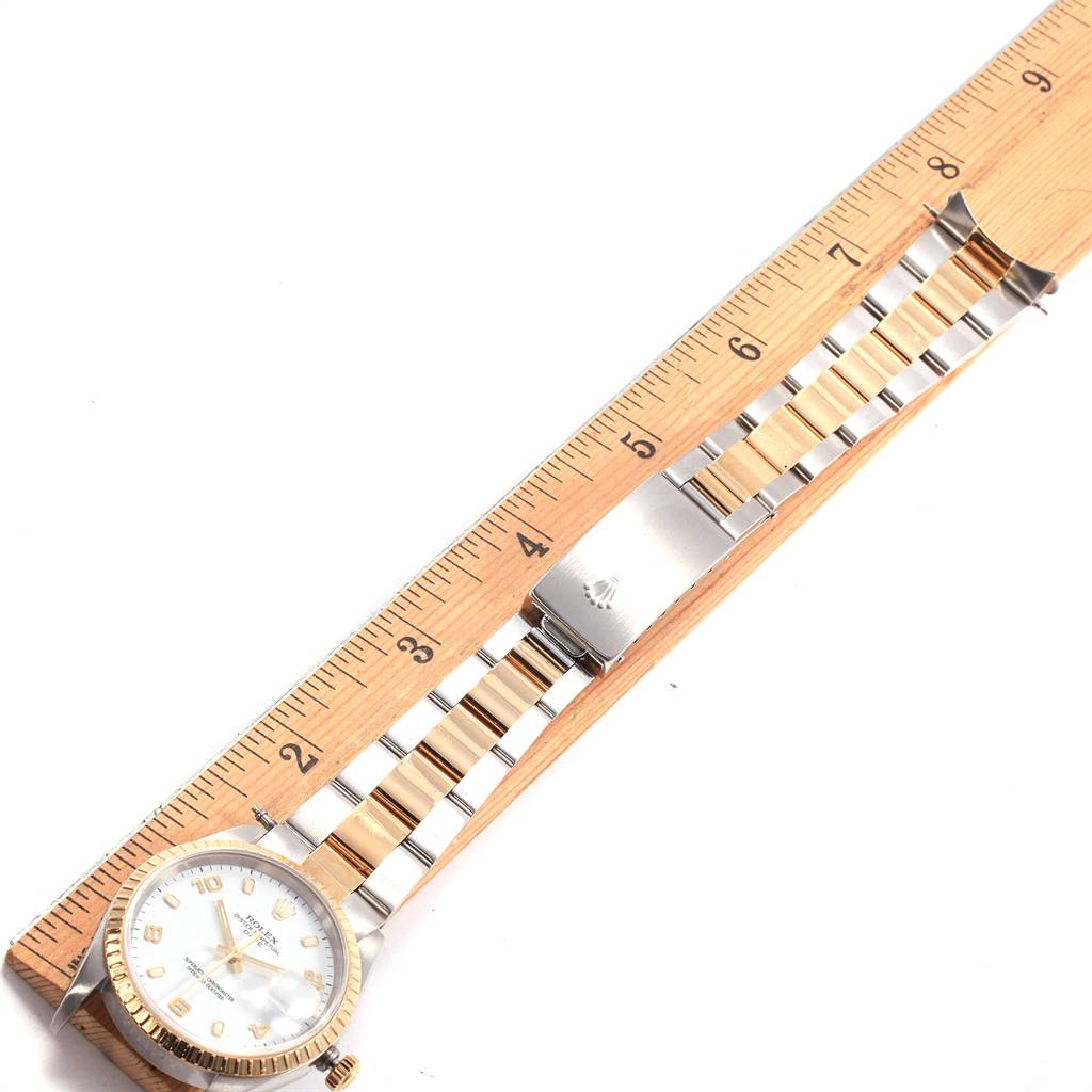 The image shows a Rolex Date 15223 Men's Steel and Gold (two tone) White Dial 15223 Men's Steel and Gold (two tone) White Dial model watch with ruler measurements for its bracelet and clasp from a top-down angle.