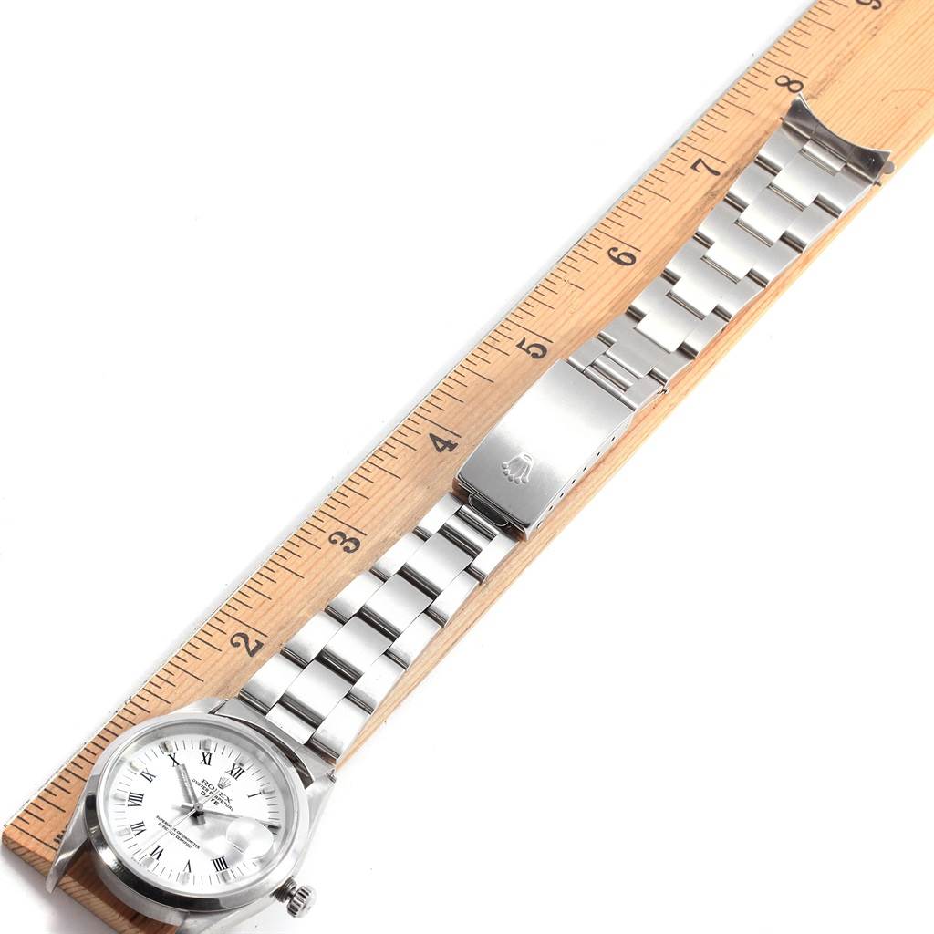 The image shows a Rolex Date 15200 Men's Stainless Steel White Dial 15200 Men's Stainless Steel White Dial model watch laid flat on a ruler, displaying the face, bracelet, and clasp.