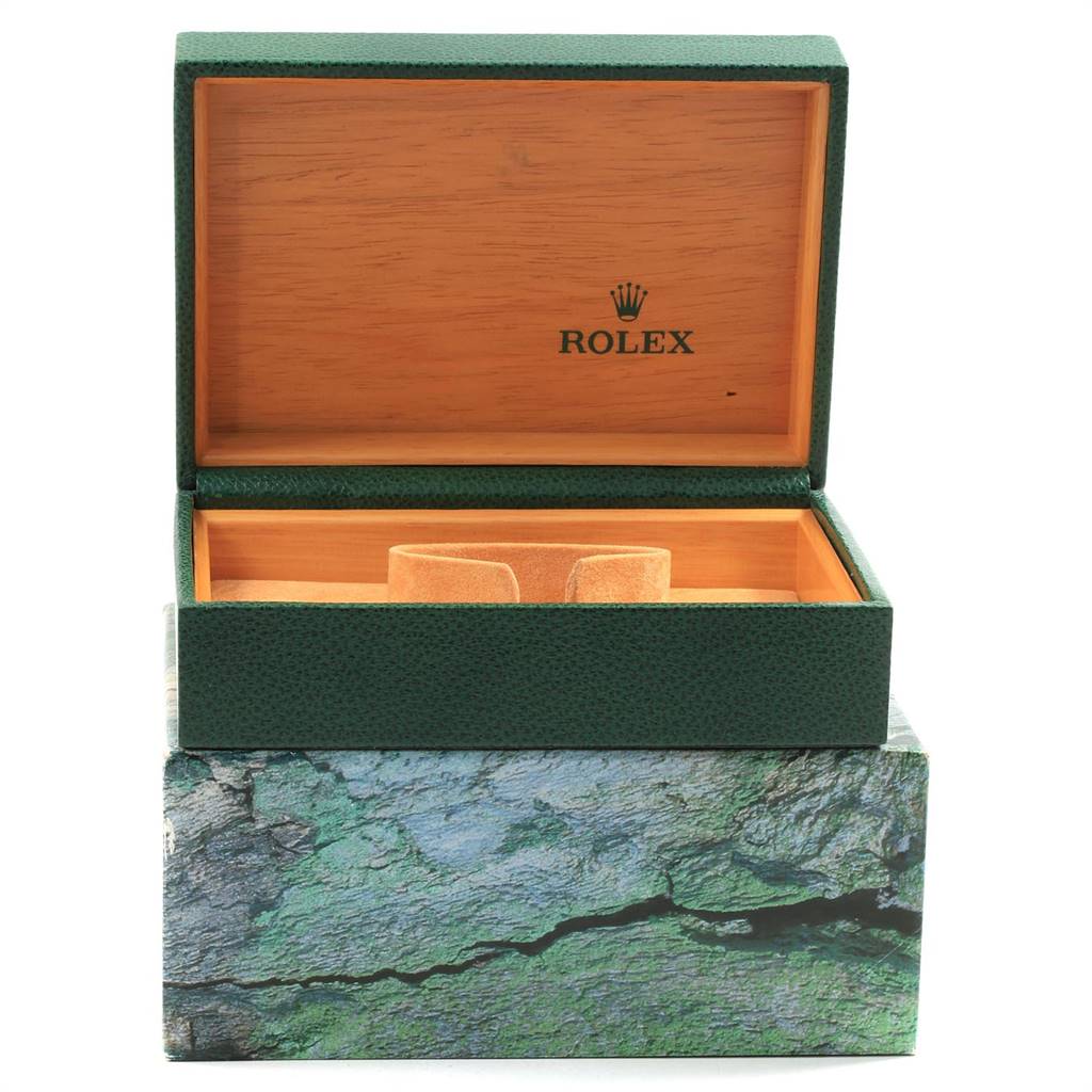 The image shows an opened Rolex green and wood watch box for the Date model, with an inner cushion for the watch.