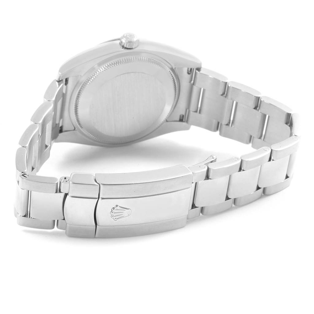 This image shows the back case and bracelet clasp of a Rolex Date 115234 Stainless Steel Pink Dial 115234 Stainless Steel Pink Dial model watch at an angle.