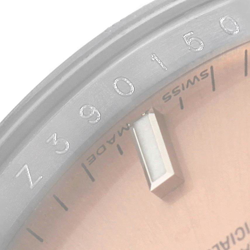 The image shows a close-up of the dial and part of the bezel of a Rolex Date 115234 Stainless Steel Pink Dial 115234 Stainless Steel Pink Dial model watch.