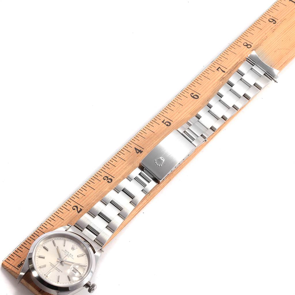 This image shows the front view of a Rolex Date 15200 Men's Stainless Steel Silver Dial 15200 Men's Stainless Steel Silver Dial watch, including the face, bracelet, clasp, and a wooden ruler for scale.