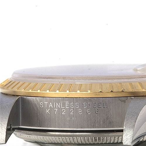 This image shows a side view of a Rolex Date 15223 Men's Stainless Steel Champagne Dial 15223 Men's Stainless Steel Champagne Dial model watch focusing on the bezel, case, and part of the serial number.