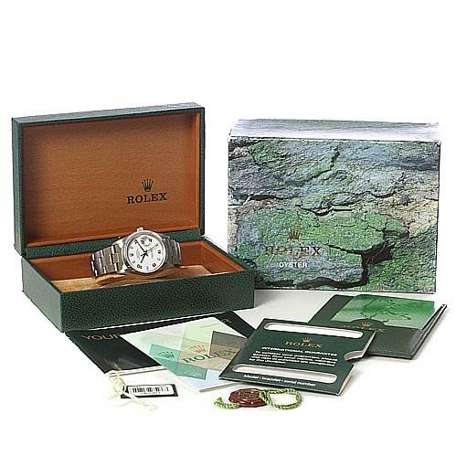 The image shows a Rolex Date 15200 Men's Stainless Steel White Dial 15200 Men's Stainless Steel White Dial model watch at an angle inside an open green box, alongside booklets, tags, and a warranty card.
