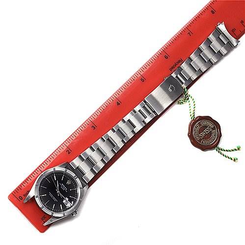 The image shows a Rolex Date 15210 Men's Stainless Steel Black Dial 15210 Men's Stainless Steel Black Dial model watch laid flat next to a ruler, displaying the face, bracelet, clasp, and a "Swiss Made" tag.