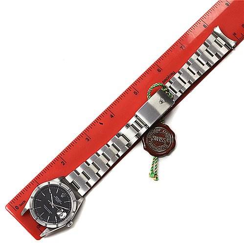 This image shows a Rolex Date 15210 Men's Stainless Steel Black Dial 15210 Men's Stainless Steel Black Dial model watch from a top-down angle, featuring the watch face, bracelet, and clasp, alongside a ruler.