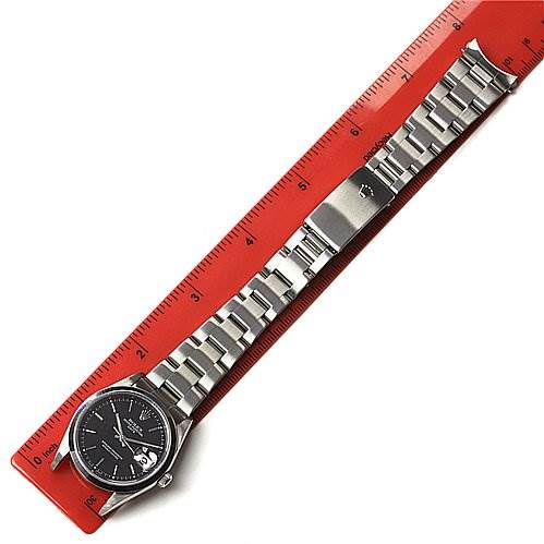 The image shows a Rolex Date 15210 Men's Stainless Steel Black Dial 15210 Men's Stainless Steel Black Dial model watch laid flat next to a red ruler, displaying the entire watch including the dial, bracelet, and clasp.
