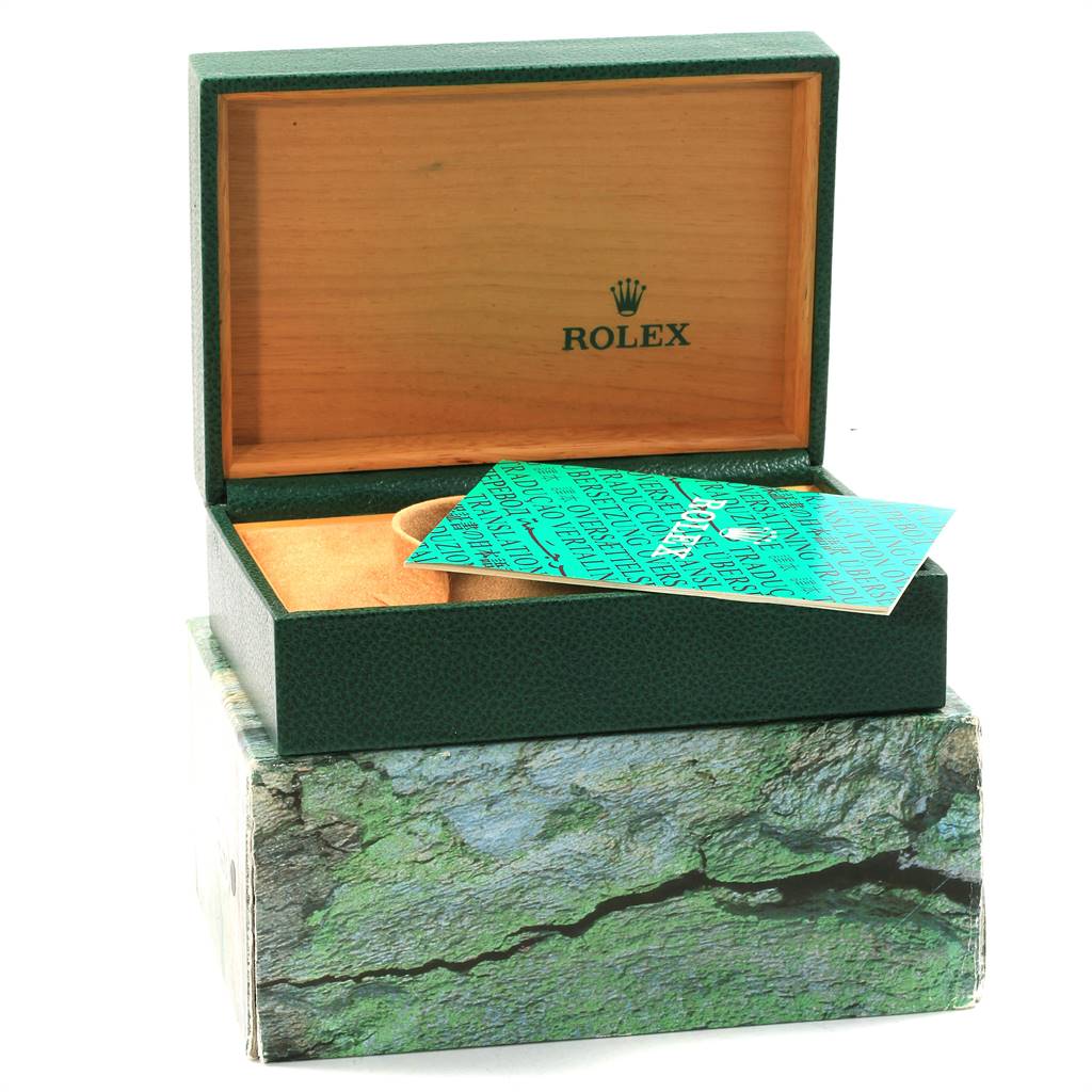 This image shows an open Rolex watch box for the Date model, with a green card partially inside the box.