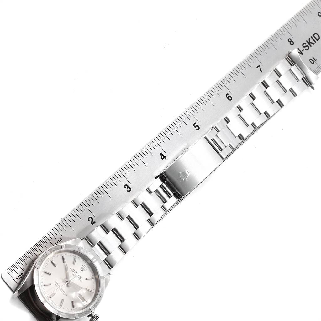 The image shows a top-down view of a Rolex Date 15210 Men's Stainless Steel Silver Dial 15210 Men's Stainless Steel Silver Dial model watch with its face, bracelet, and clasp aligned against a ruler.
