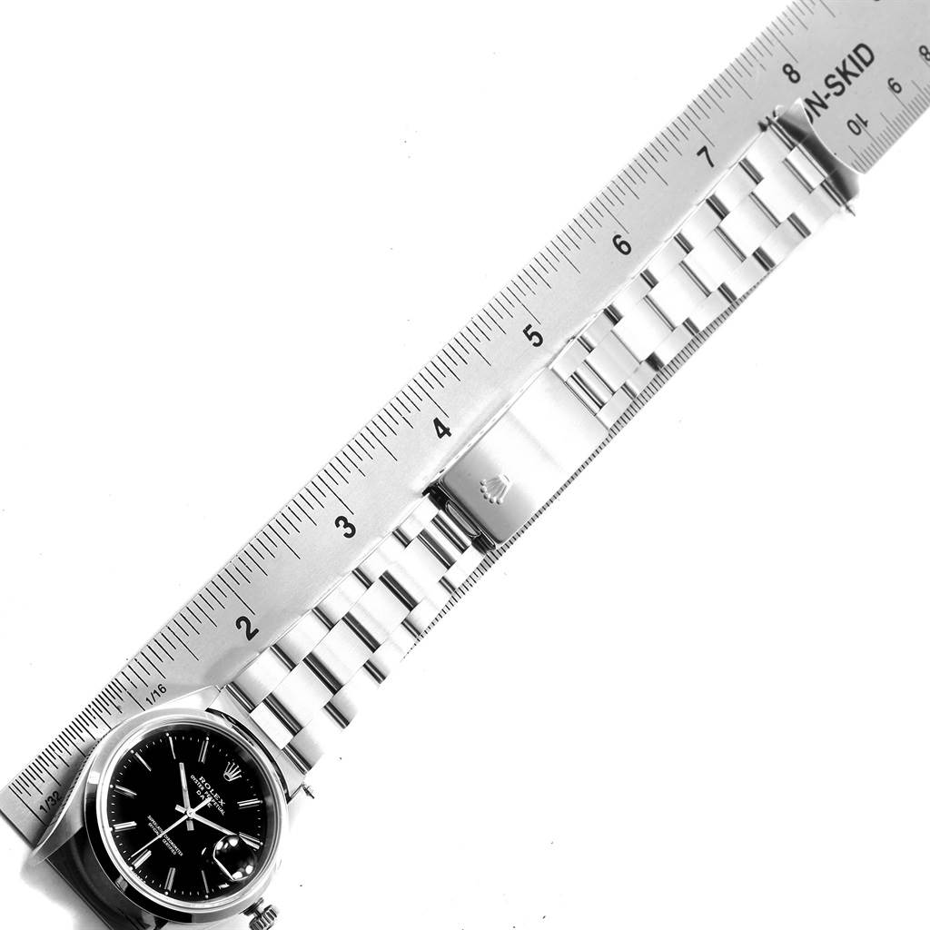 The image shows a Rolex Date 15200 Men's Stainless Steel Black Dial 15200 Men's Stainless Steel Black Dial watch placed next to a ruler, highlighting its face, bracelet links, and clasp.