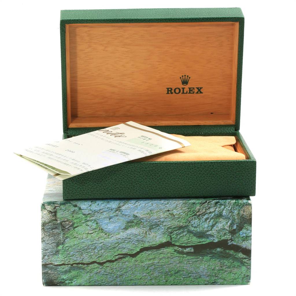 The image shows a Date model Rolex box, partially open with documents and a protective cloth inside.