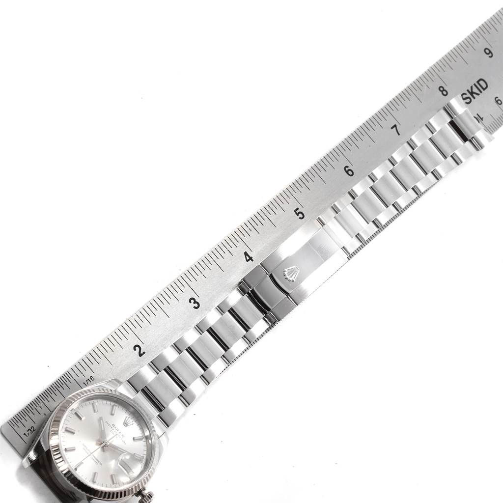 The image shows a Rolex Date 115234 Men's Stainless Steel Silver Dial 115234 Men's Stainless Steel Silver Dial watch partially, with its bracelet and clasp next to a ruler for measurement.