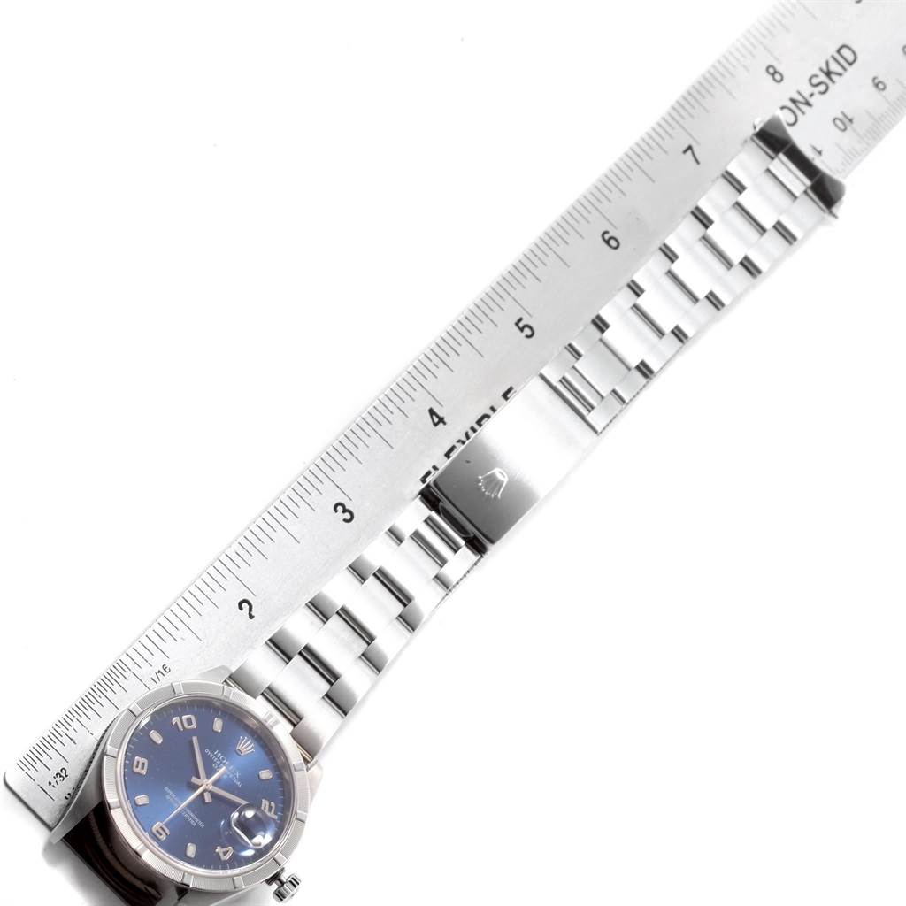 The image shows the Rolex Date 15210 Men's Stainless Steel Blue Dial 15210 Men's Stainless Steel Blue Dial watch laid flat, aligned with a ruler, highlighting the face and bracelet.